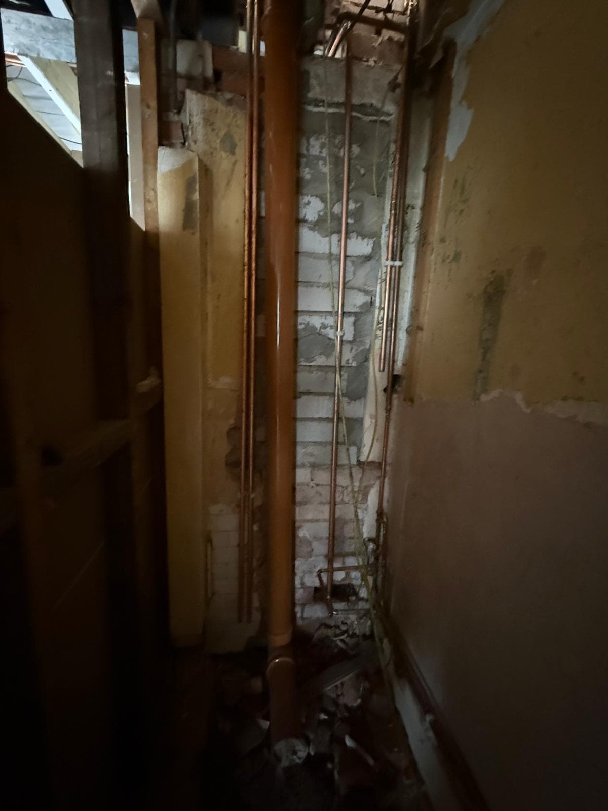 A bathroom stripped back to bare brick and old pipes before the work